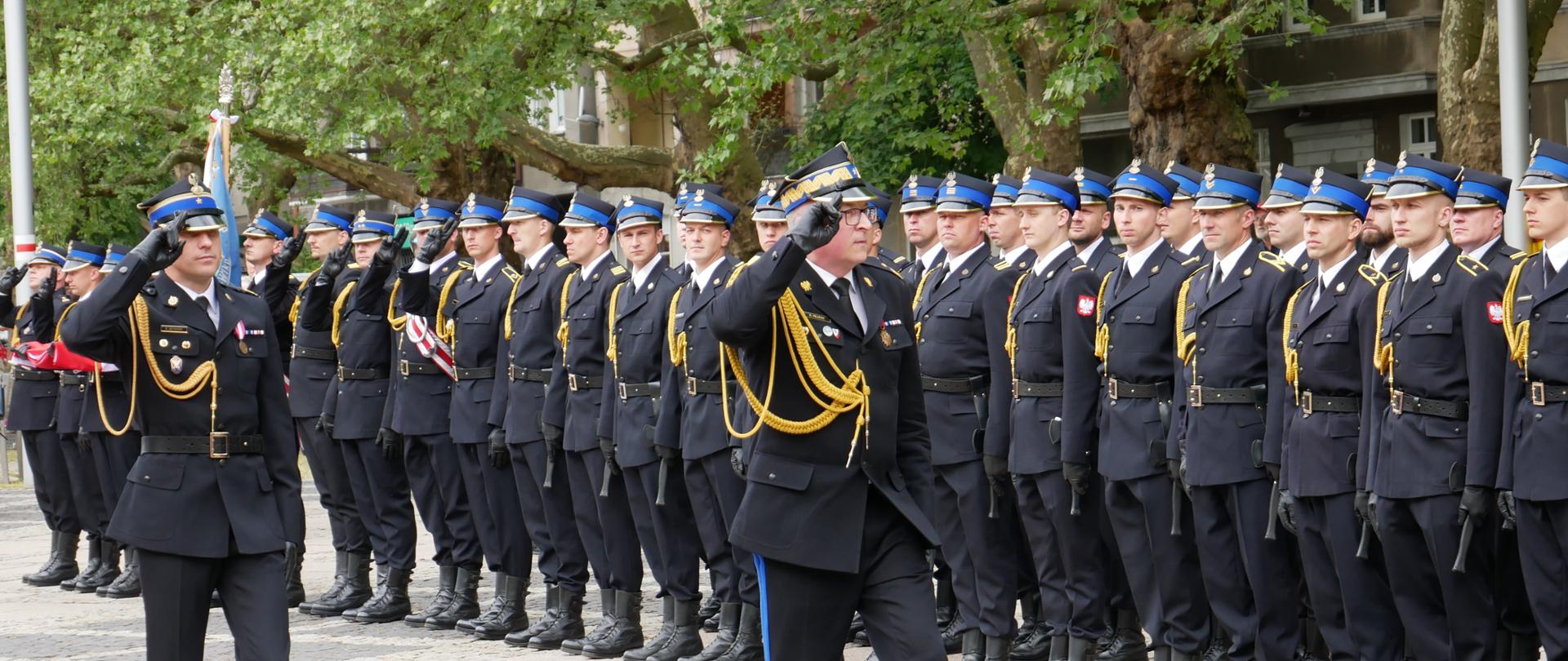 Zastępca KG PSP wraz z dowódcą uroczystości maszerują przed pododdziałem strażaków salutując