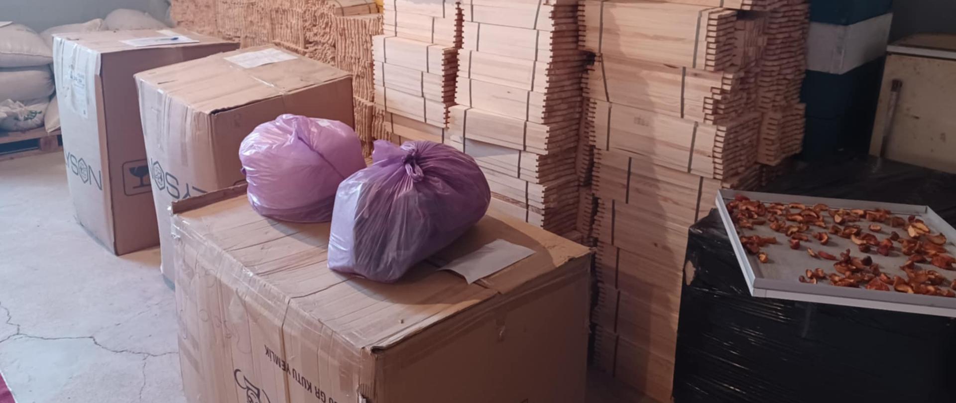 Magazyn z pudłami i kartonami, w których jest sprzęt dla pszczelarzy