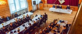 Na zdjęciu członkowie lokalnej jednostki OSP w umundurowaniu strażackim siedzą uczestniczą w zebraniu