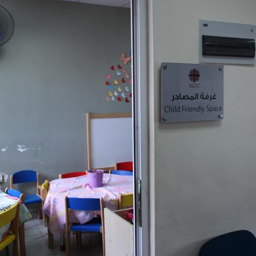 tabliczka informacyjna o sali zabaw dla dzieci z informacją, iż jest to miejsce prowadzone przez Caritas Jordania