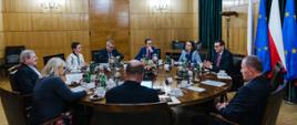 Spotkanie, przy stole premier Mateusz Morawiecki, minister finansów Magdalena Rzeczkowska, Johannes Hahn komisarz Unii Europejskiej ds. budżetu i administracji. 