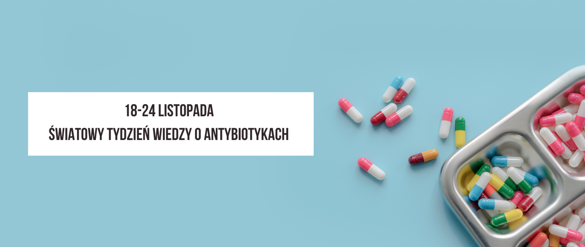 Na niebieskim tle z prawej strony metalowy pojemnik w którym znajdują się kolorowe tabletki: biało-niebieskie, biało-różowe, biało-czerwone, żółto-zielone, oraz bordowo -żółte. Kilka tabletek rozsypanych poza pojemnikiem.