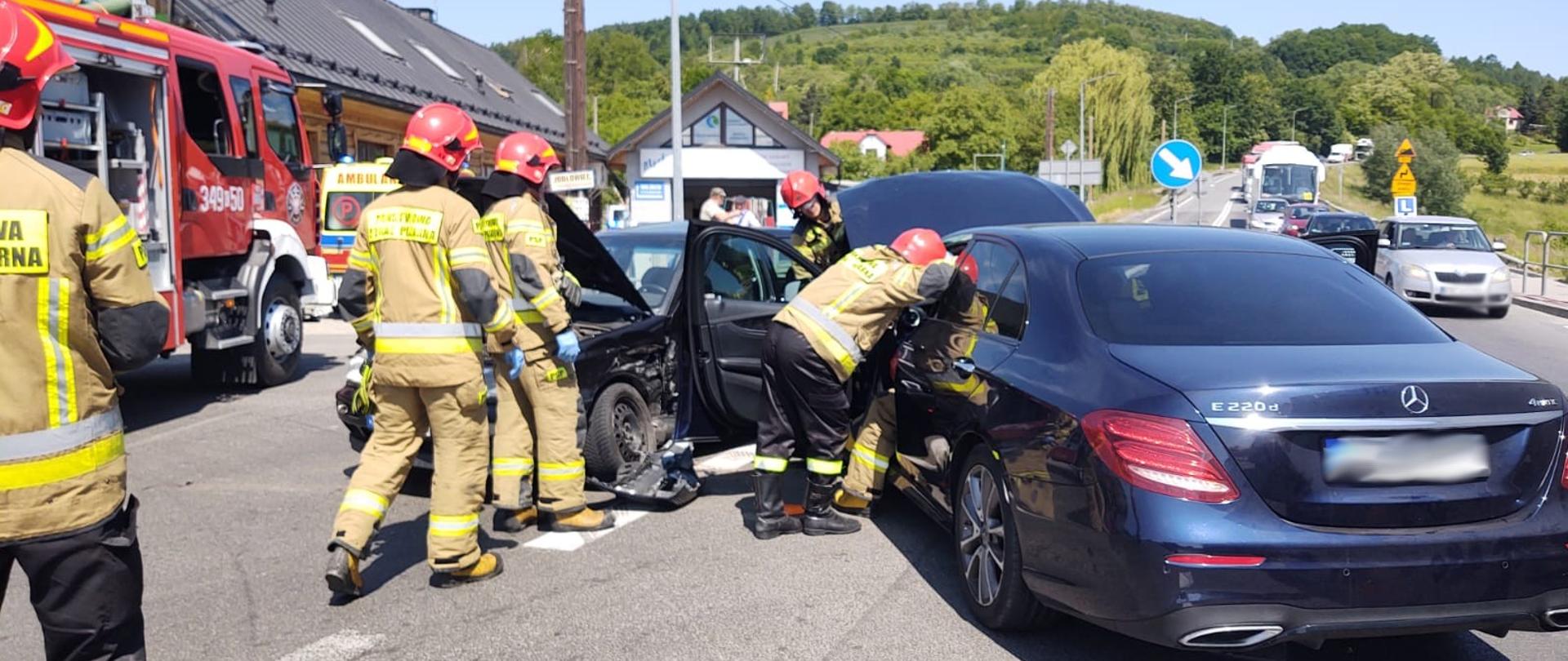 Strażacy prowadzą działania przy uszkodzonych samochodach