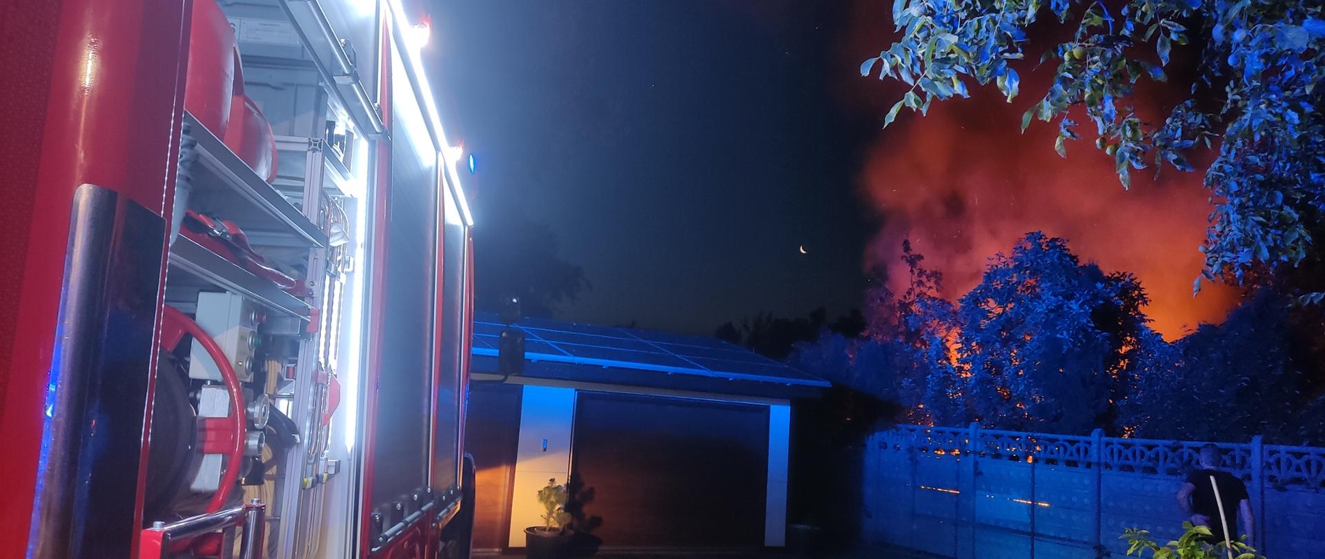 Samochód strażacki na tle pożaru.