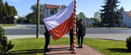 Dzień Flagi RP - Strażacy przygotowują flagę do powieszenia
