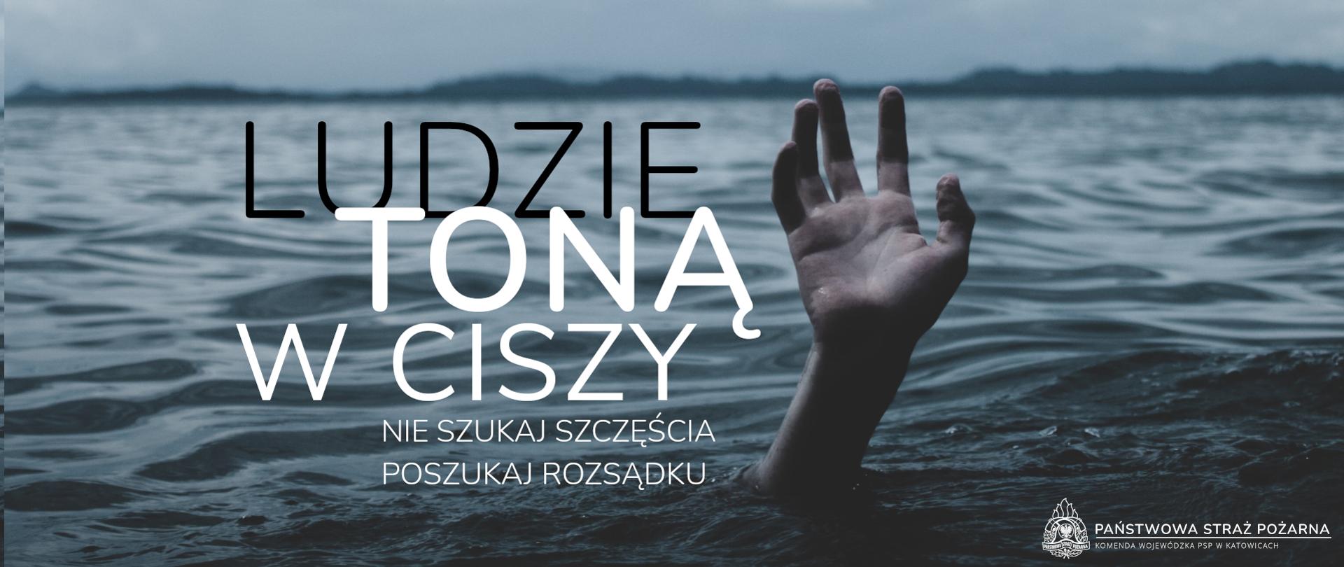 ilustracja przedstawia akwen. Ponad wodą widać dłoń, po lewej stronie napis Ludzie toną w ciszy. Nie szukaj szczęścia, poszukaj rozsądku. W prawym dolnym rogu napis Państwowa Straż Pożarna KW PSP w Katowicach.
