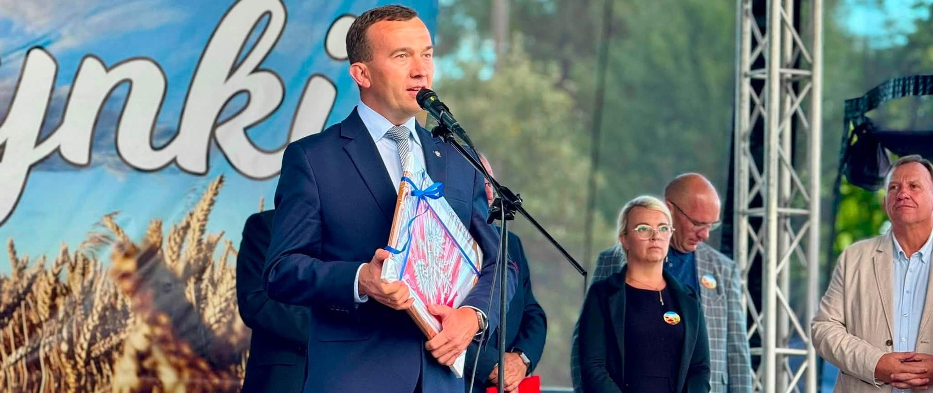 Mężczyzna stoi na scenie i przemawia 