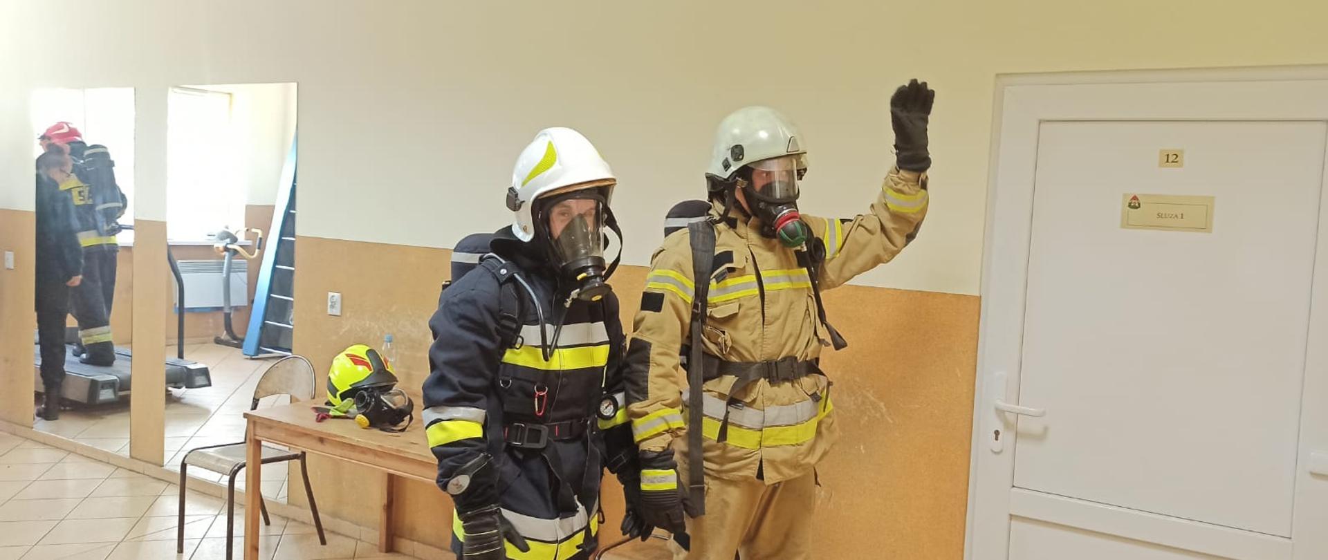 Zdjęcie przedstawia dwoje strażaków ubranych w ubranie specjalne, sprzęt ochrony dróg oddechowych podczas testu w komorze dymowej w Wojewódzkim Ośrodku Szkolenia PSP w Bornem Sulinowie.