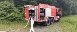 Ćwiczenia jednostek ochrony przeciwpożarowej w lesie. Na zdjęciu samochód strażacki.