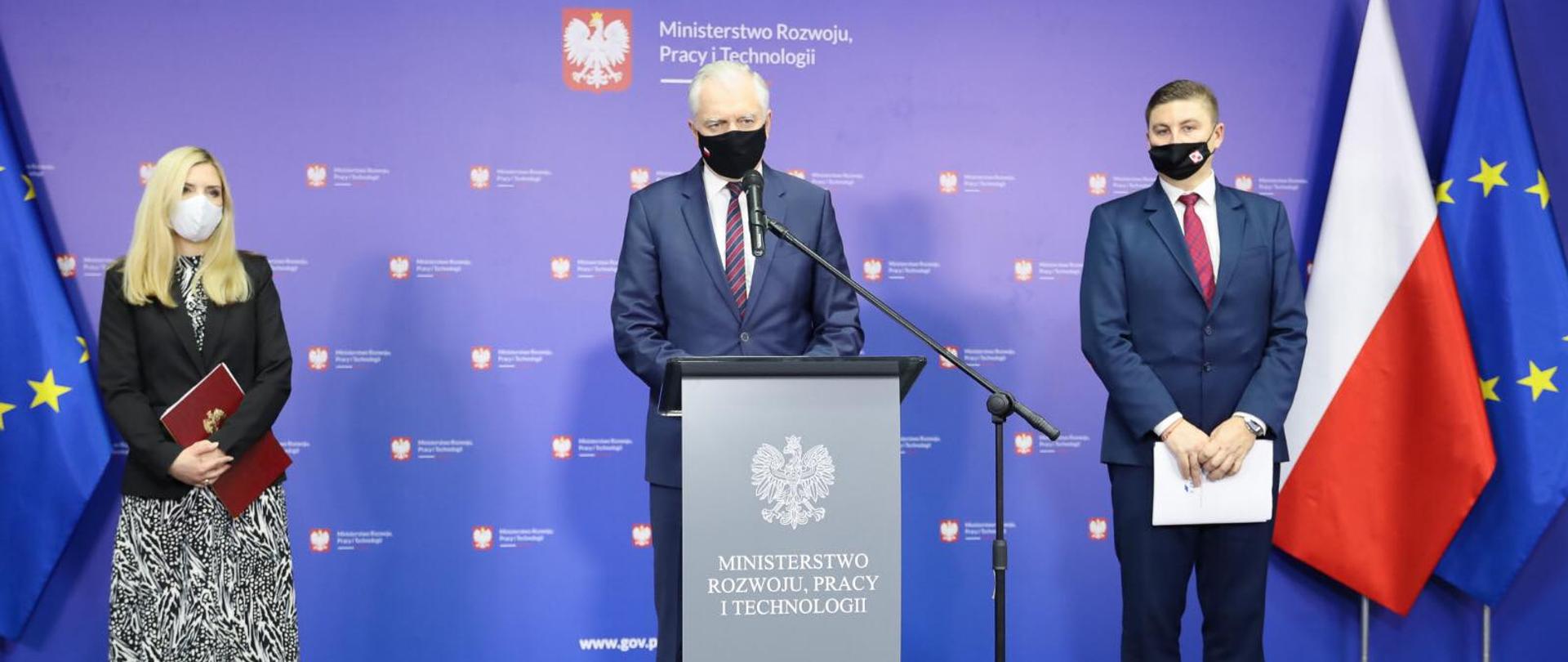 na zdjęciu przy mikrofonie stoją wiceminister Anna Kornecka (z lewej), wicepremier Jarosław Gowin (w środku) i Bartłomiej Druziński, prezes Krajowego Zasobu Nieruchomości