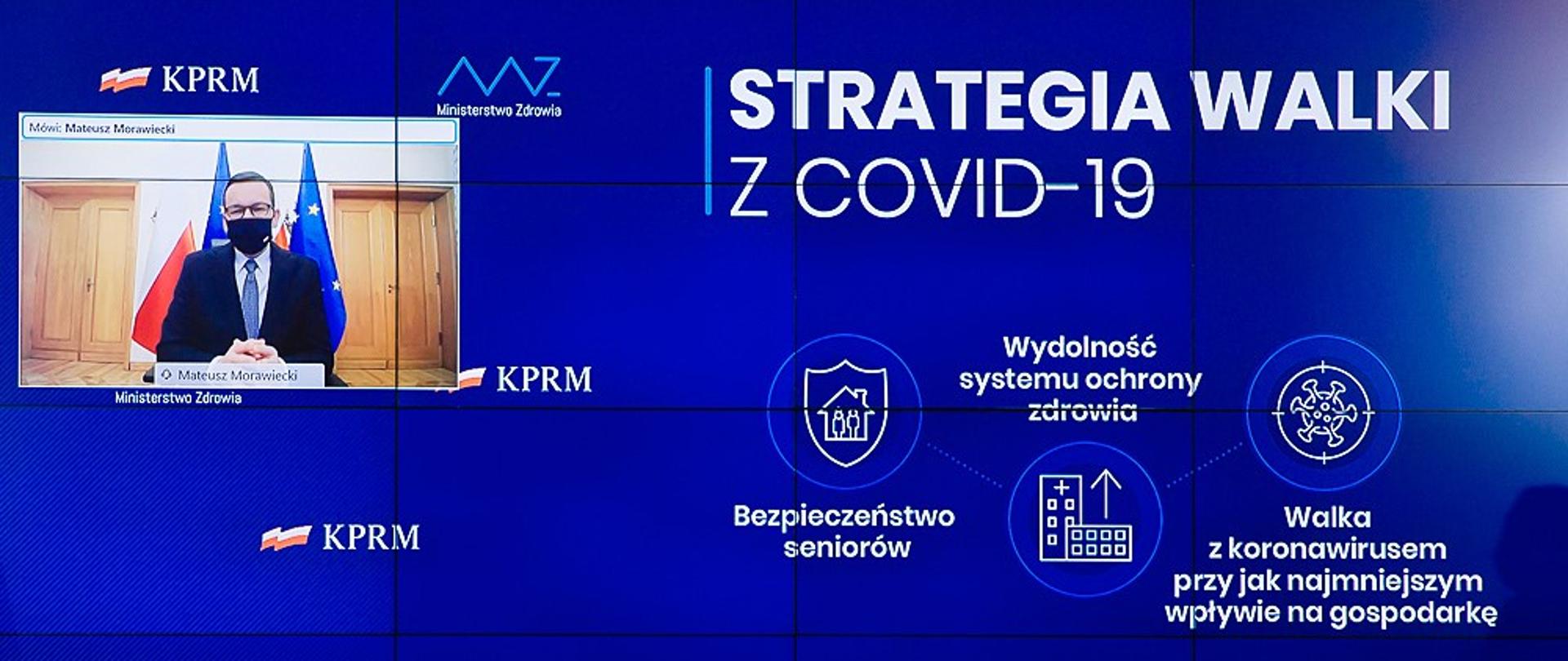 Premier Mateusz Morawiecki podczas łączenia na ścianie wizyjnej.