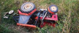Widać przewrócony ciągnik rolniczy w rowie