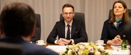 Minister rozwoju i technologii Waldemar Buda podczas rozmowy z ministrem rozwoju gospodarczego Republiki Włoskiej Giancarlo Giorgettim, minister Buda siedzi przy stole, po jego prawej stronie tłumaczka języka włoskiego Aleksandra Soroka-Kulma