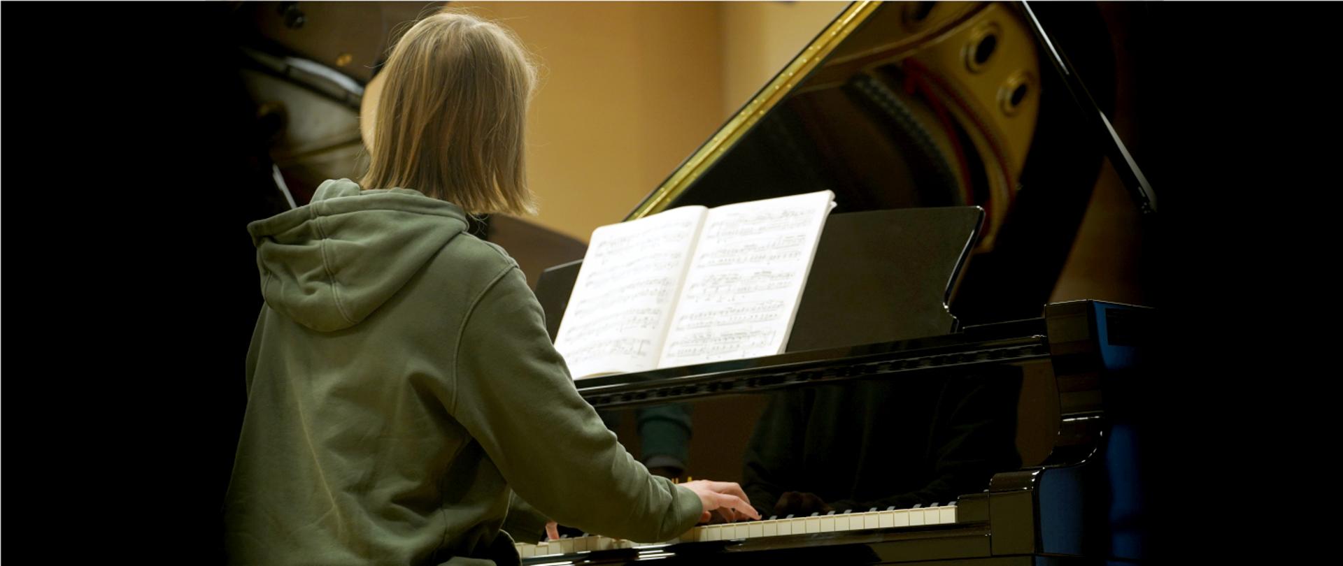Zdjęcie przedstawia uczennicę ZPSM grającą na fortepianie