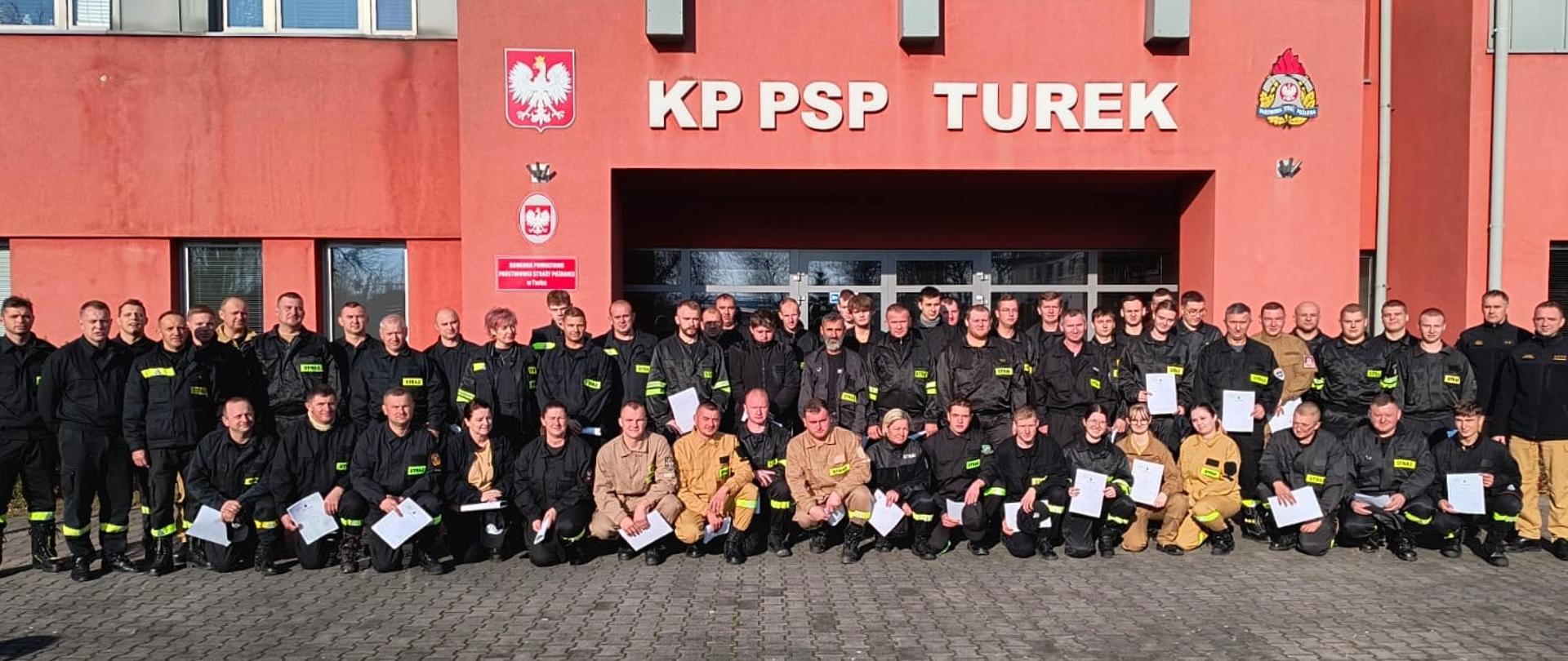 Uczestnicy szkolenia pozują do zdjęcia przed budynkiem KP PSP Turek. 