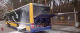 Zdjęcie na drodze publicznej. W ciągu dnia. Widać autobus z uszkodzoną komorą silnika.