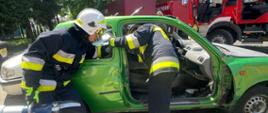 strażacy podczas próby ewakuacji osoby poszkodowanej z samochodu osobowego w trakcie założenia egzaminacyjnego