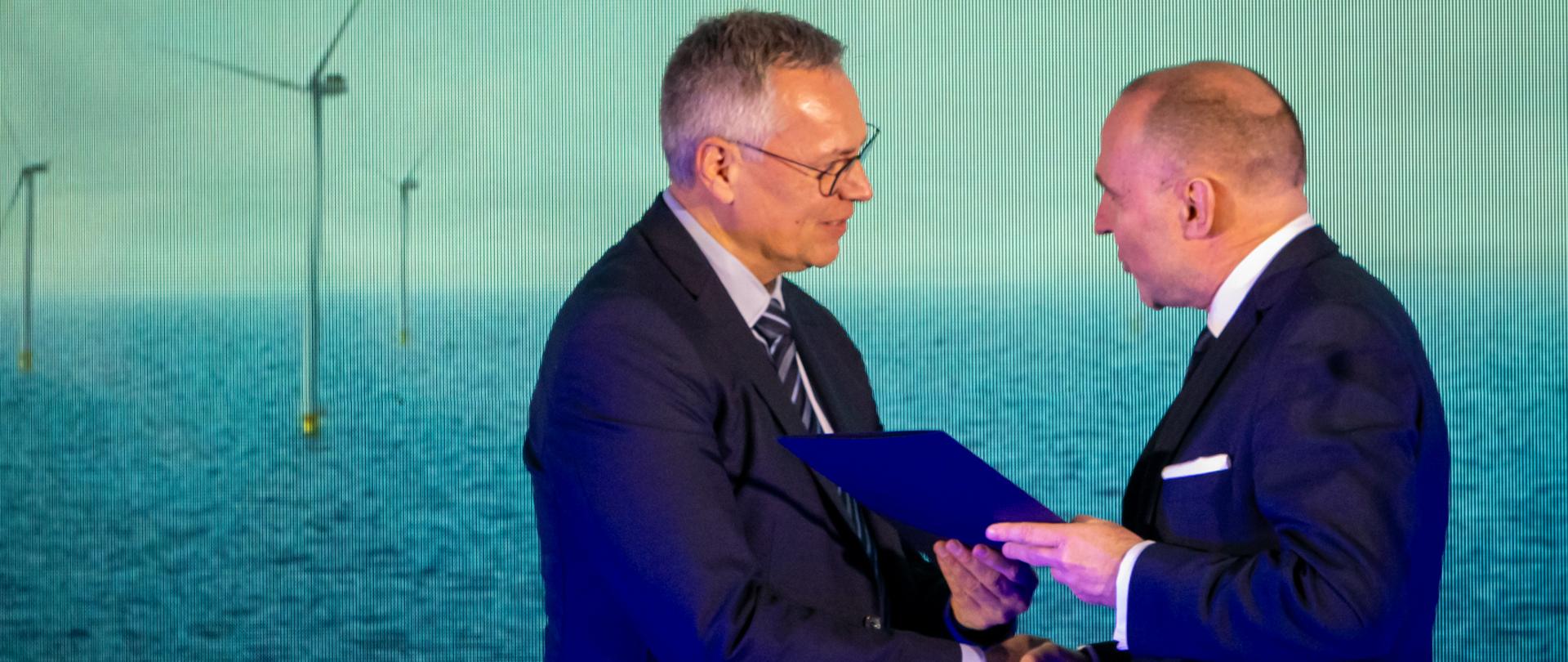 wojewoda przekazuje decyzję przedstawicielowi firmy Vestas