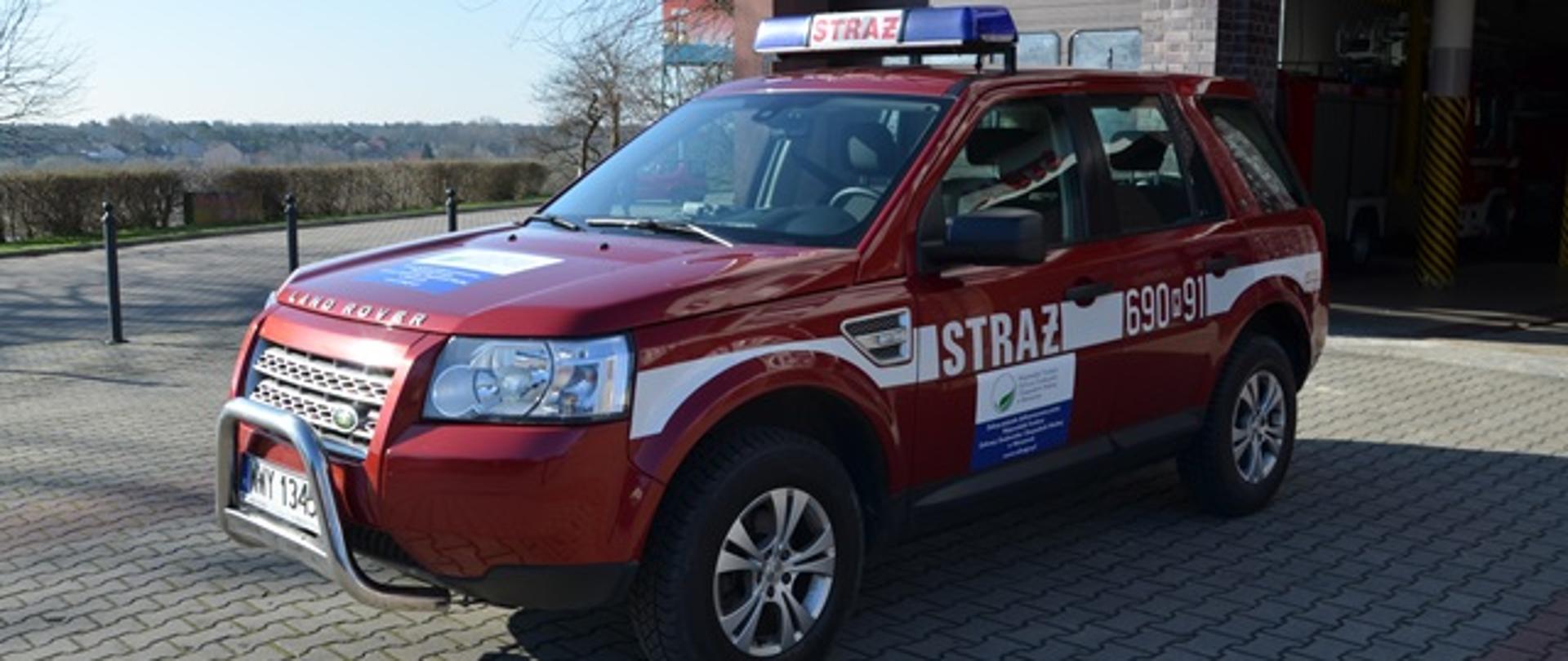 Pojazd strażacki na tle Komendy Powiatowej PSP