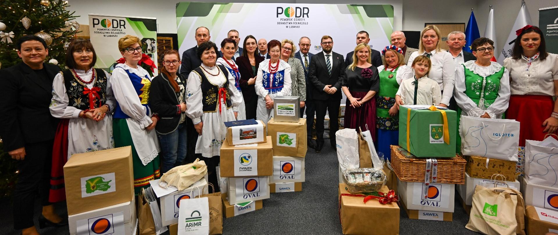 kilkanaście kobiet w strojach ludowych a także wojewoda pozują do zdjęcia