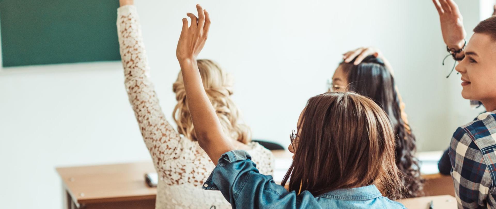 Na zdjęciu widać zgłaszającą się młodzież, będącą w klasie.