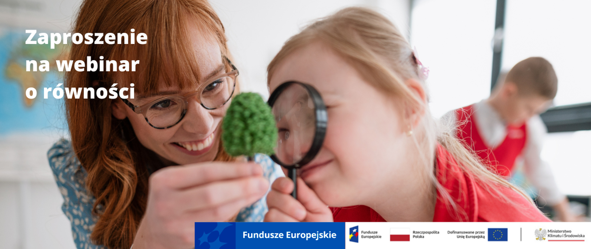 Trzy osoby. Na głównym planie dwie kobiety. Jedna starsza w okularach pokazuje młodej kobiecie przez lupę model mini drzewa. Na dalszym planie młody mężczyzna. 