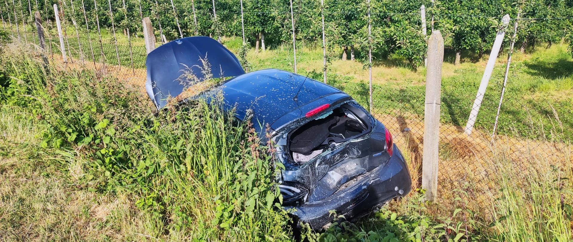 Zniszczony samochód osobowy poza drogą w fosie.