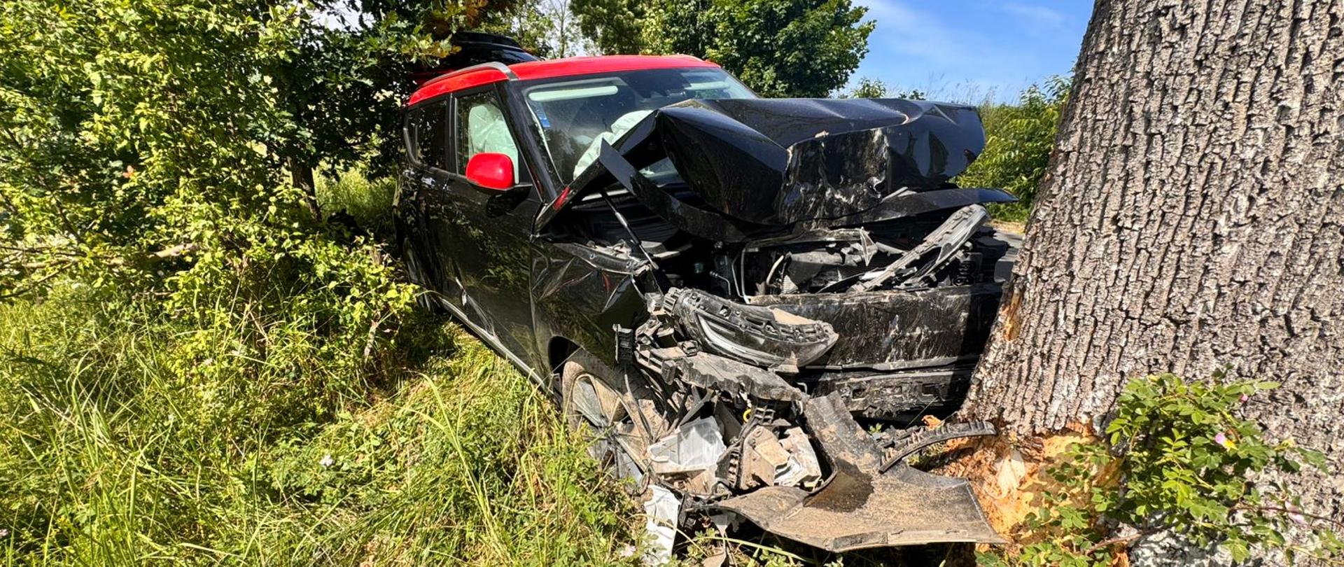 Rozbite auto elektryczne stojące na poboczu.