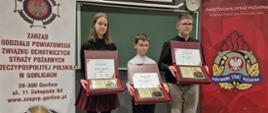 Zajęcie przedstawia laureatów trzech pierwszych miejsc w eliminacjach powiatowych Ogólnopolskiego Turnieju Wiedzy Pożarniczej w powiecie gorlickim z nagrodami i dyplomami.