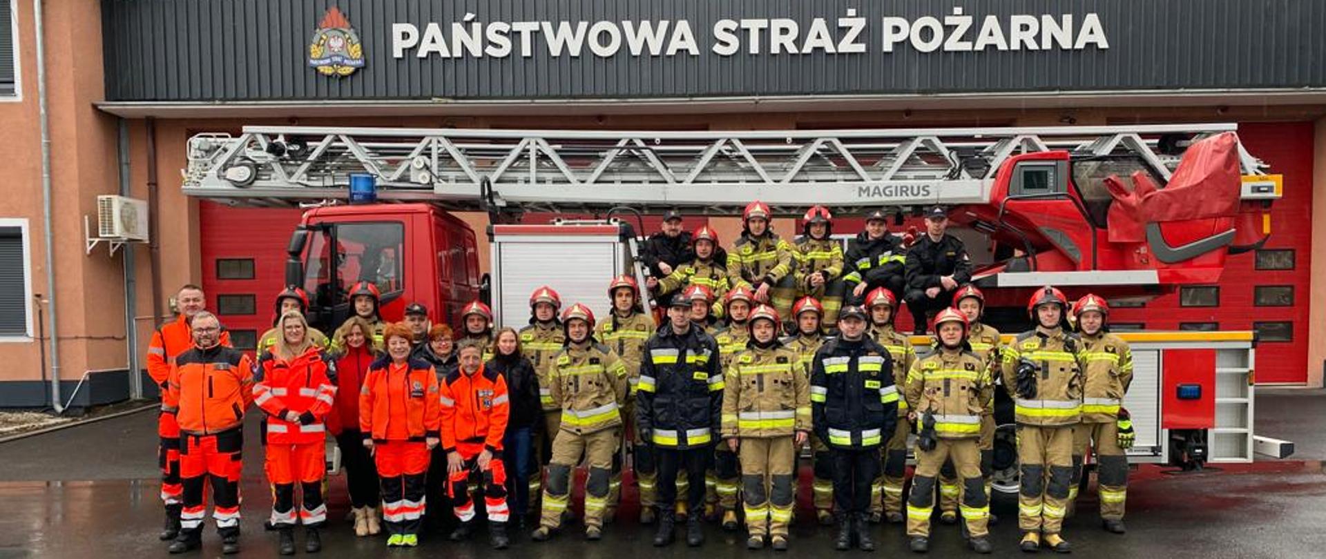 Zdjęcie Strażaków PSP i Ratowników PRM na tle drabiny pożarniczej 