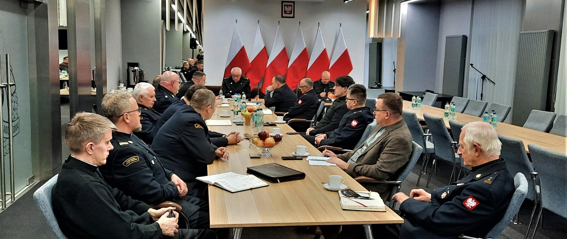 Księża kapelani siedzący przy stole podczas narady służbowej. 