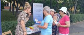 Osoby przy punkcie edukacyjnym uzyskują informacje o zdrowym stylu życia