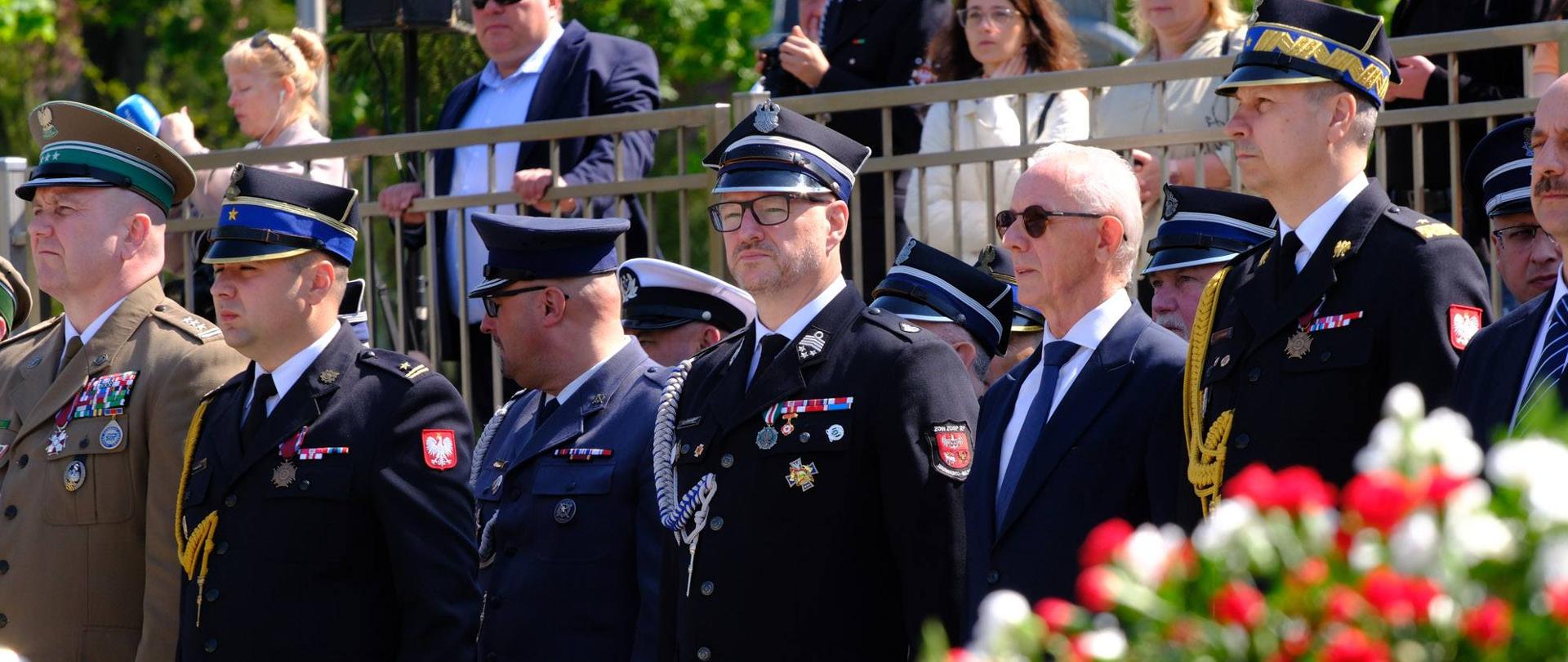 grupa oficjeli stoi na trybunach