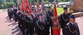 Przemarsz pocztów sztandarowych do kościoła z okazji obchodów 100-lecia OSP Ostojów