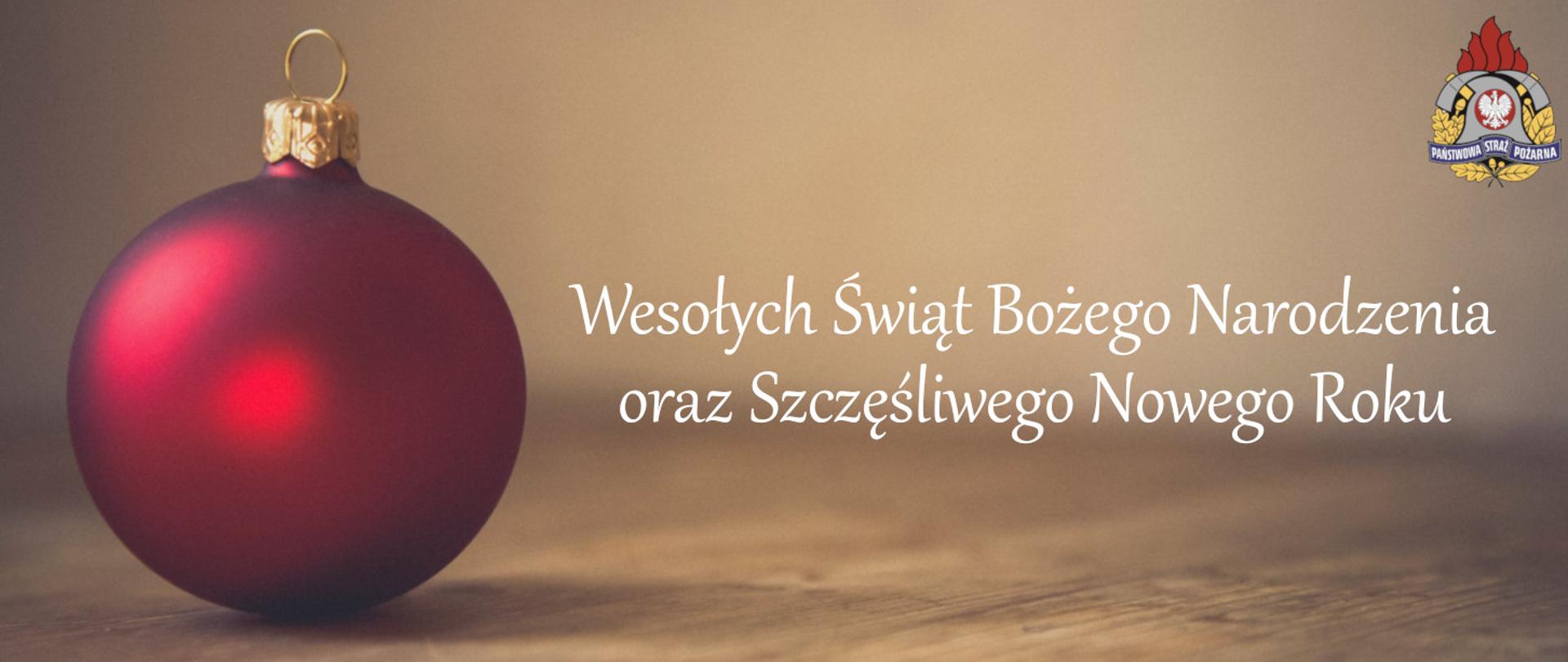 Szklana bombka w kolorze czerwonym z życzeniami Wesołych Świat Bożego Narodzenia oraz Szczęśliwego Nowego Roku, w górnym prawym rogu logo Państwowej Straży Pożarnej