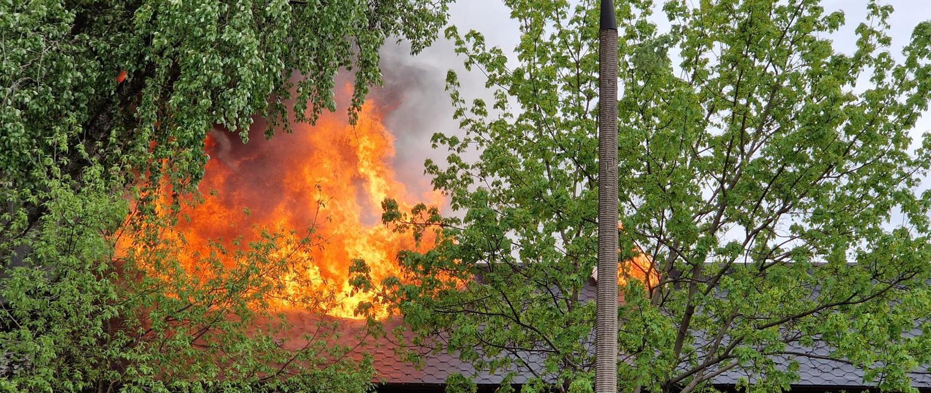 Płomienie na dachu budynku