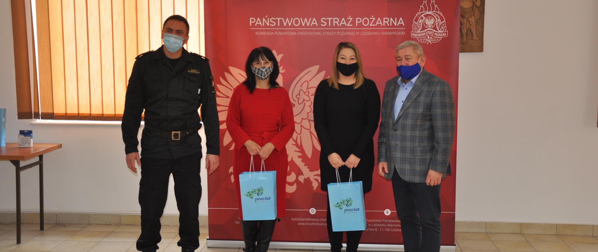 Na zdjęciu znajduje się starosta lidzbarski, komendant powiatowy PSP oraz dwie nagrodzone Panie 