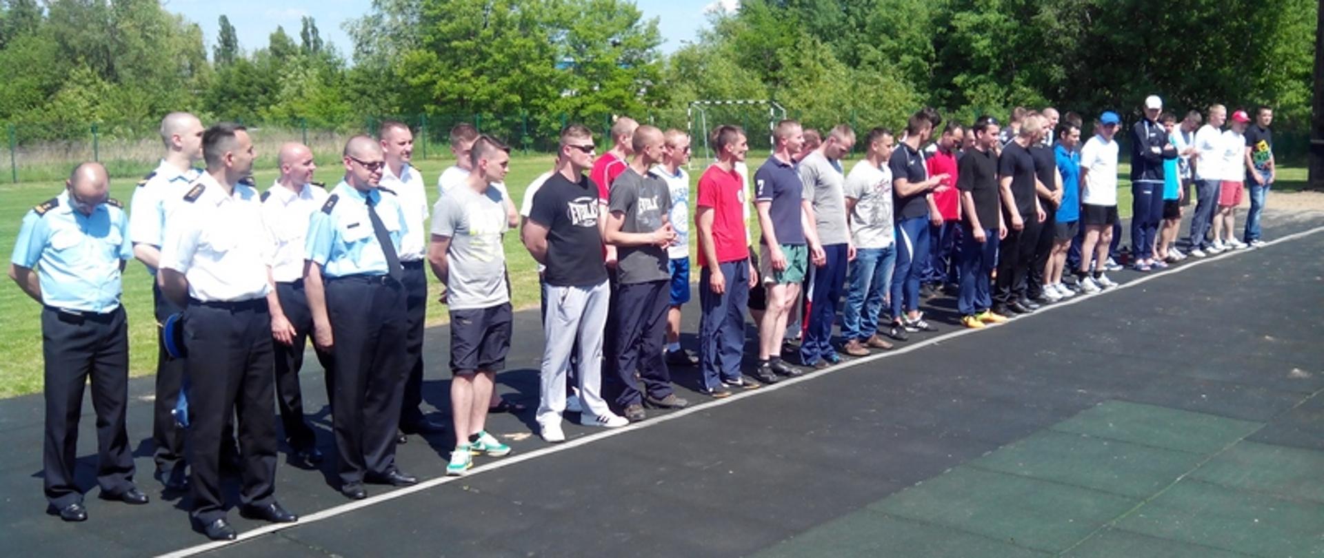 Zdjęcie przedstawia zawodników oraz sędziów zawodów podczas zbiórki w szergu