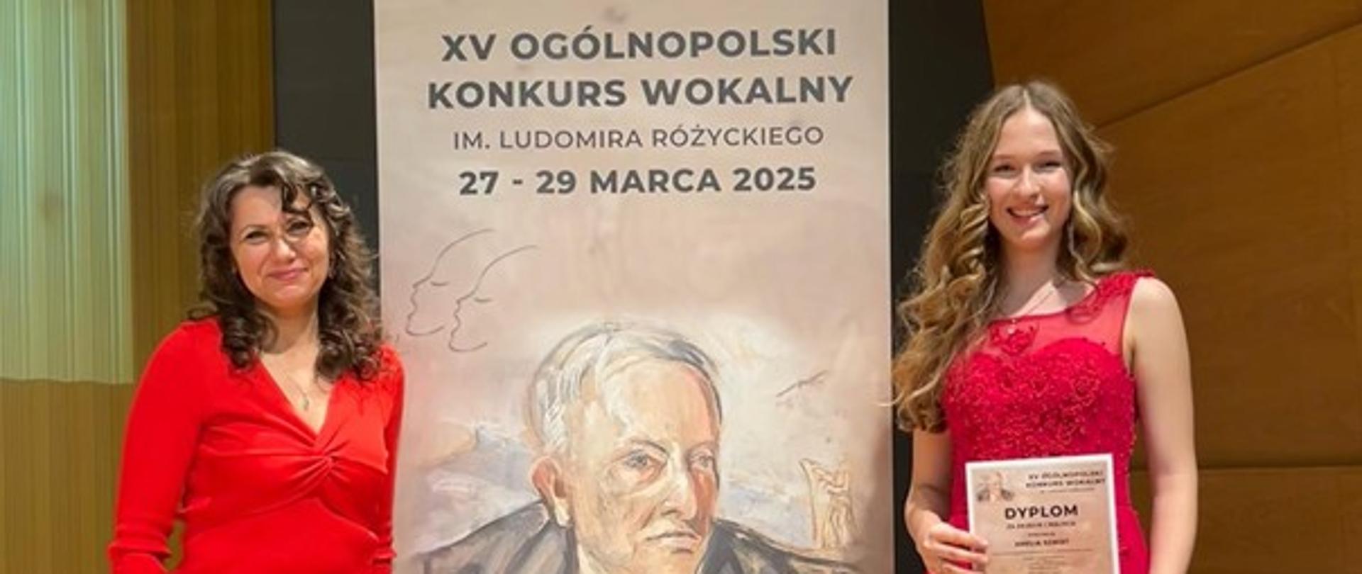 Pani Monika Brewczak i uczennica Amelia Szmidt przy plakacie Ogólnopolskiego Konkursu Wokalnego w Gliwicach. 