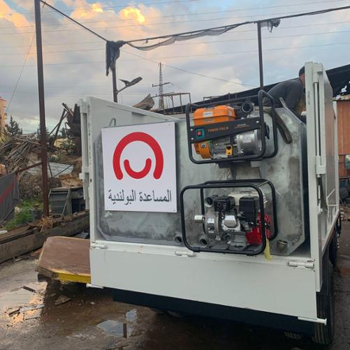 Pojazd będący zbiornikiem na wodę z logo Polska pomoc w alfabecie arabskim 