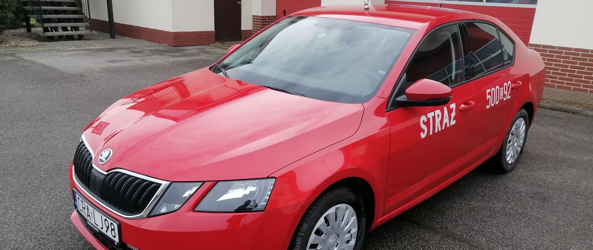 Zdjęcie przedstawia czerwony samochód SLOP Skoda Octavia na tle garażu KP PSP.