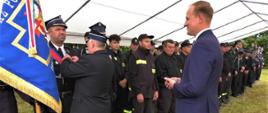 Na zdjęciu widzimy wręczanie odznaczenia strażakom