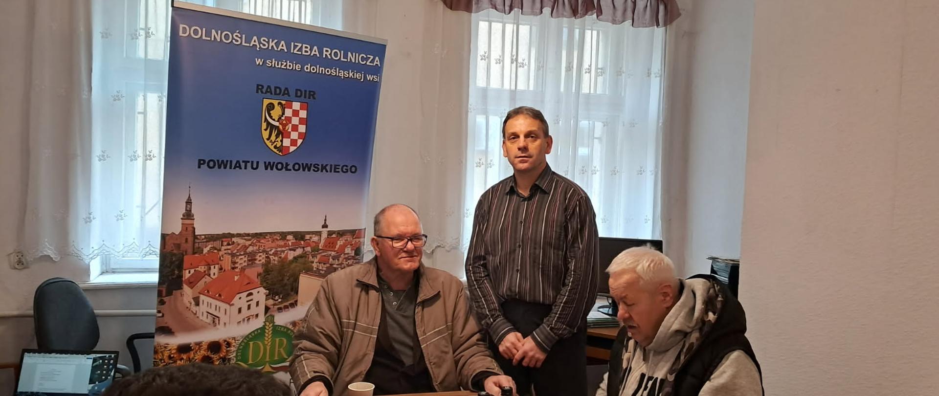 Przy stole siedzi dwóch mężczyzn: p. Jerzy Truś – Przewodniczący DIR Wołów oraz p. Karol Sygnatowicz – Delegat DIR Karol Sygnatowicz – Delegat DIR. Za nimi stoi p. Adam Klarzyński – Kierownik Oddziału w Wołowie.