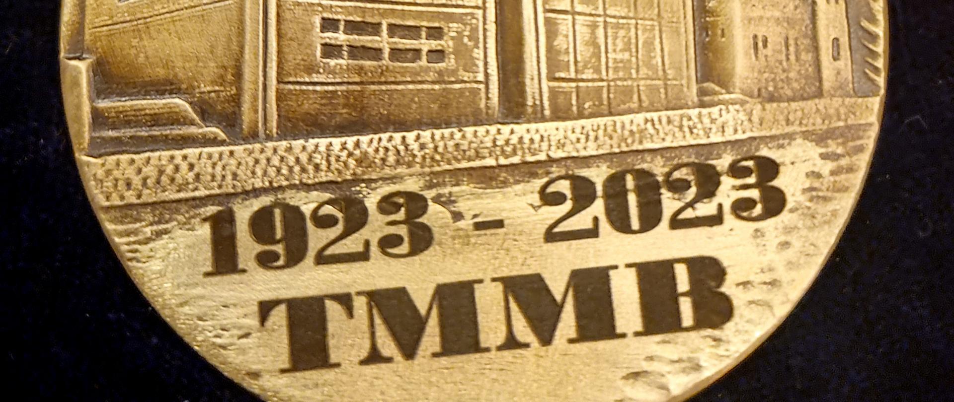 na zdjęciu medal przedstawiający spichrze bydgoskie poniżej data 1923-2023 i skrót TMMB to znaczy Towarzystwo Miłośników Miasta Bydgoszczy