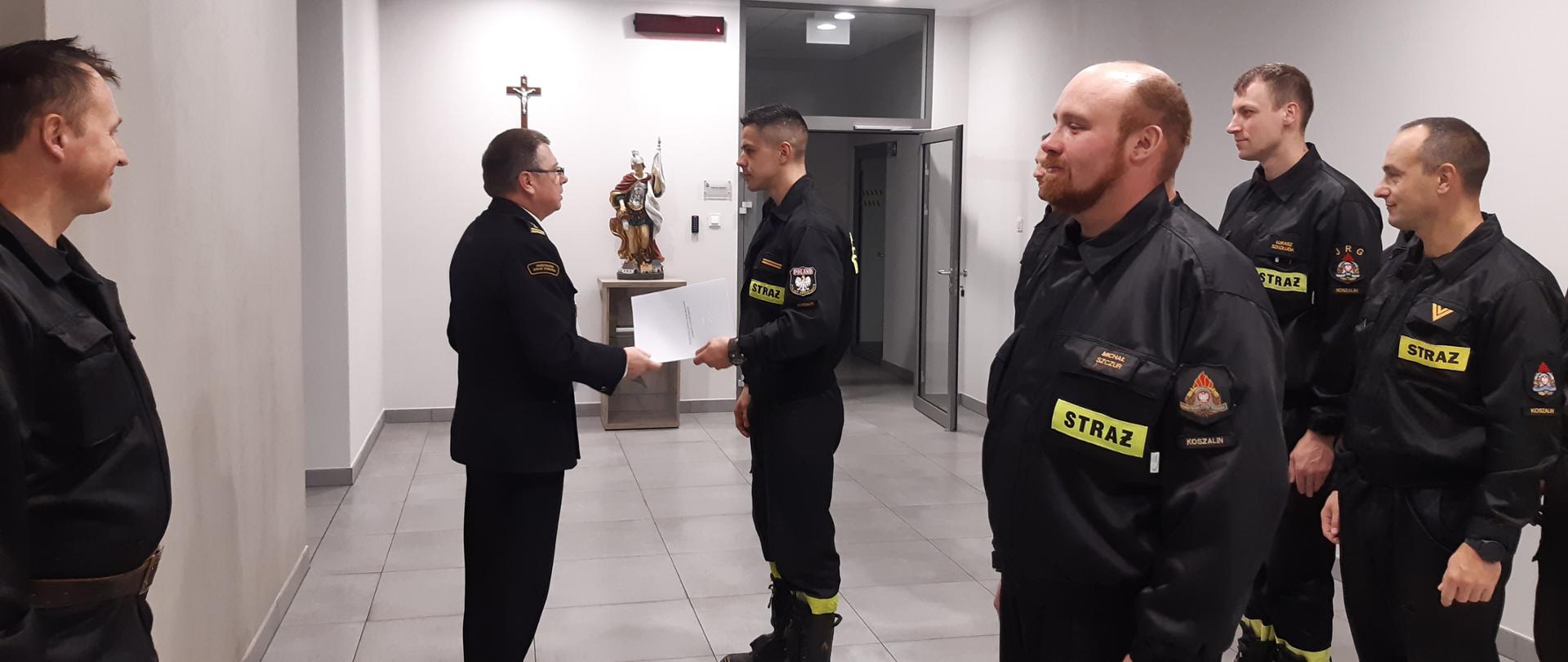 Wręczenie nagrody dla strażaka biorącego udział w misji zagranicznej. Wręczanie decyzji komendanta głównego.