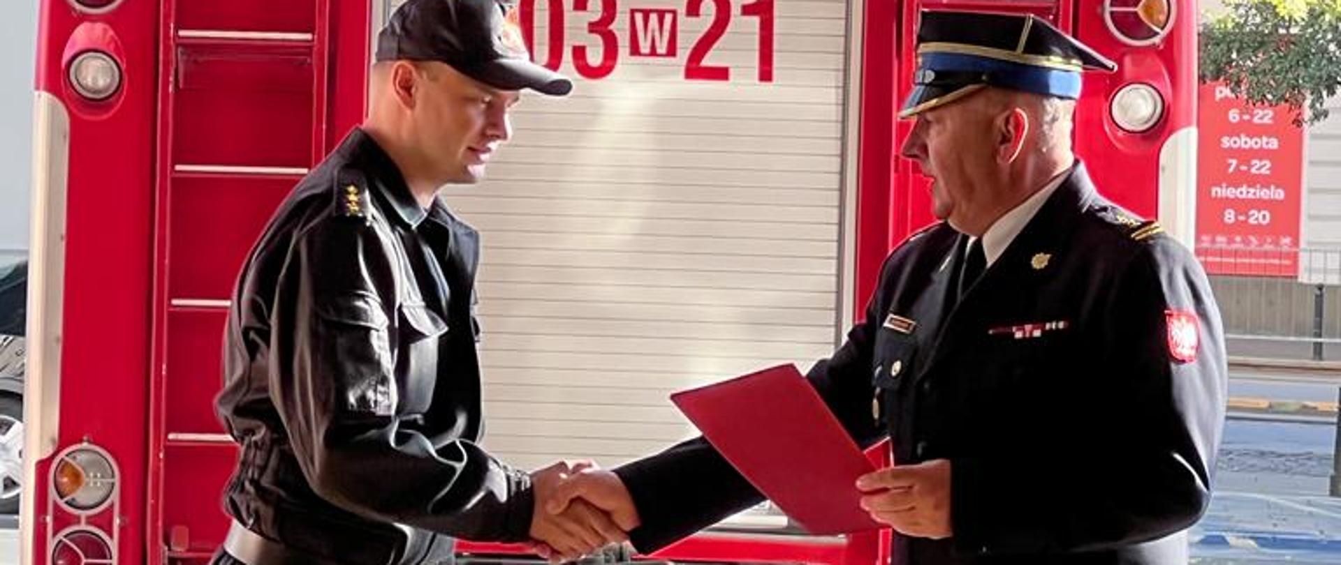 Na zdjęciu widoczny KM wręczający akt mianowania kpt. Łubiance i składający gratulacje