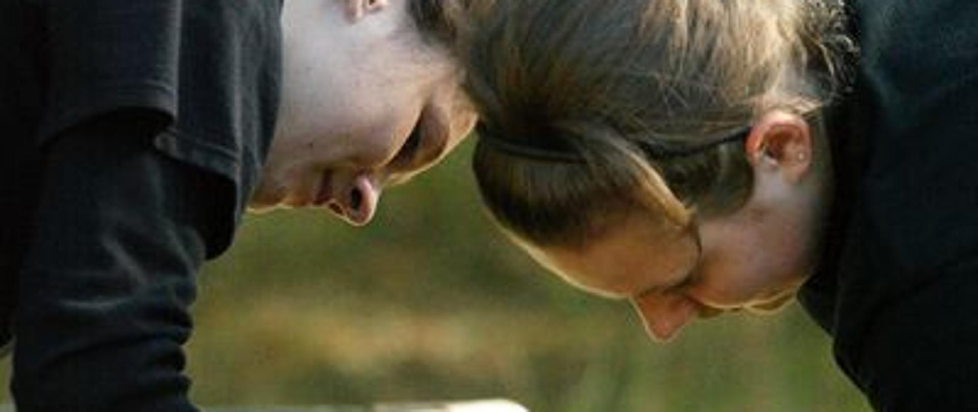 Zdjęcie przedstawia strażaczki podczas łączenia węży ssawnych