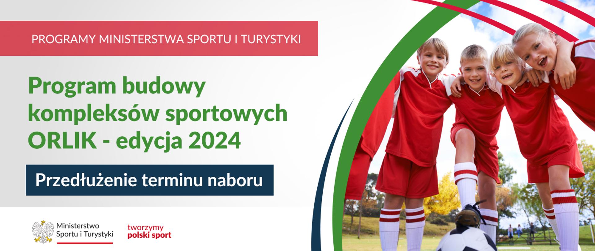 Dzieci w strojach piłkarskich w kolorze czerwonym i białych getrach z czerwonymi paskami stoją w kręgu. Chłopiec pośrodku trzyma stopę na leżącej na ziemi piłce nożnej w biało-czarne łaty. W tle zielona trawa oraz drzewa.