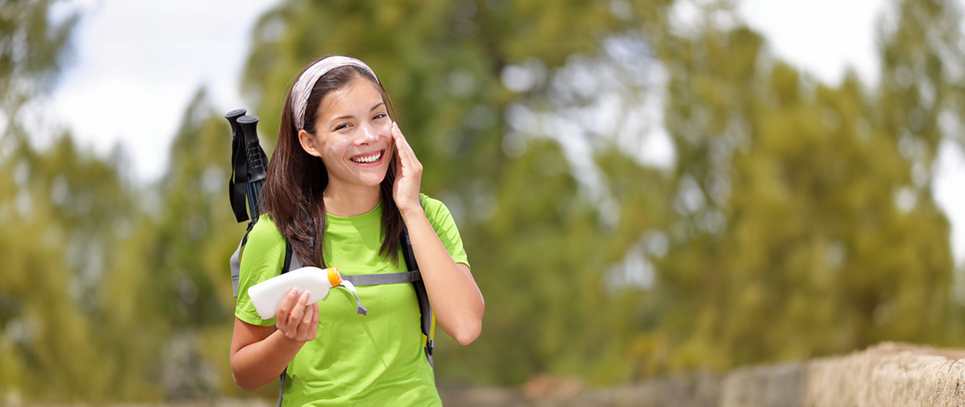 kobieta w trakcie wycieczki smaruje się kremem z filtrem przeciwsłonecznym