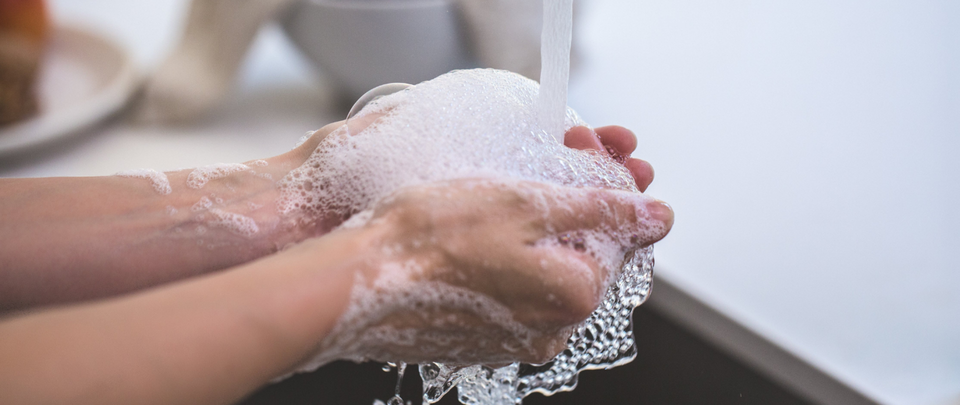Ręce myte pod strumieniem wody z pianą
